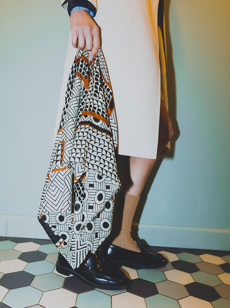 Kobieta z beżowym szalem w dłoni